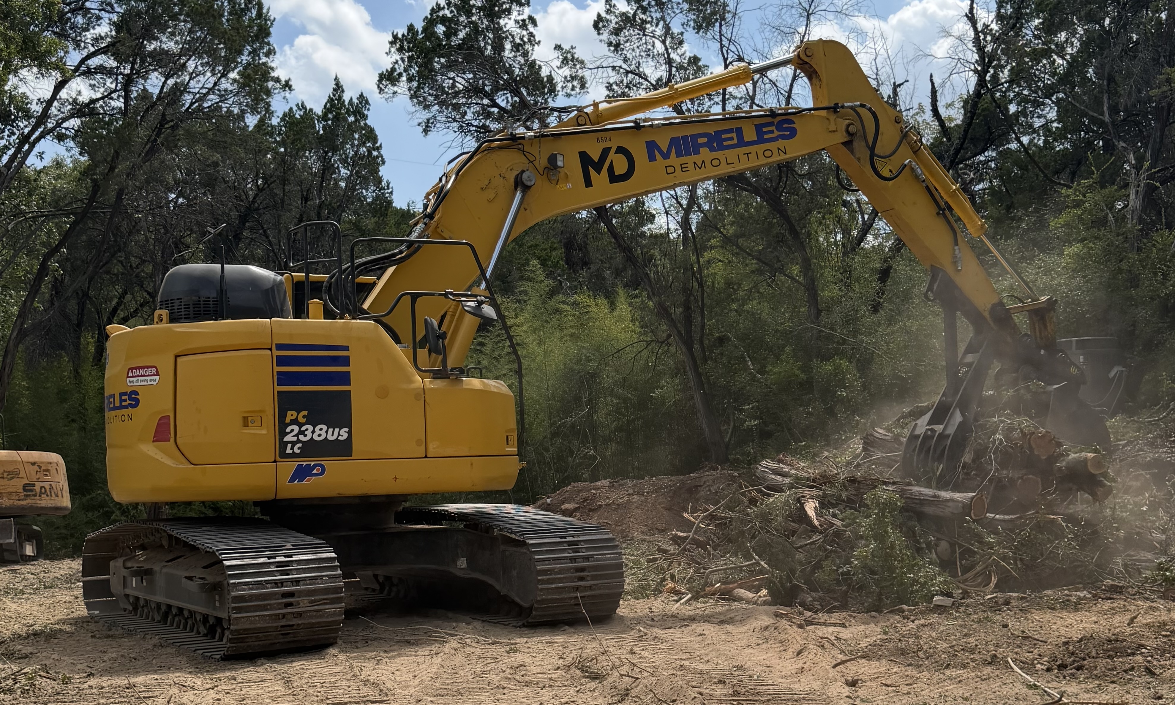 Mireles Demolition excavator clearing trees and brush